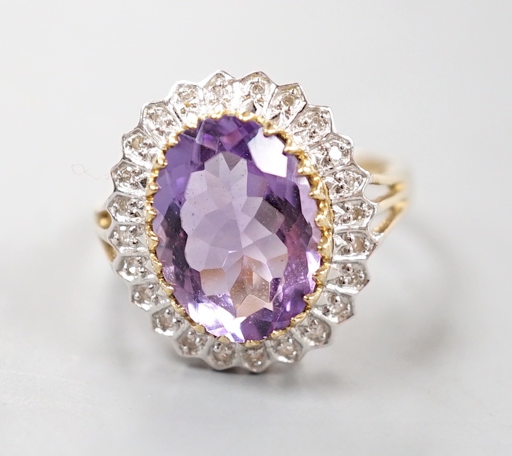 A modern 9ct gold, amethyst and diamond chip set oval cluster ring, size Q, gross weight 4.6 grams.